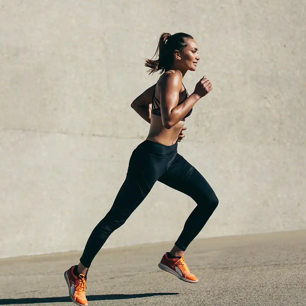 Designed to support womens unique needs. A woman runs across the frame.